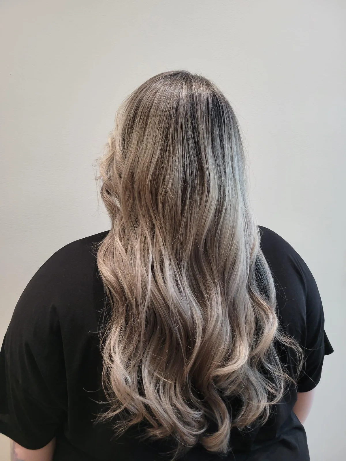 Long cool ash balyage blonde waves photographed from behind