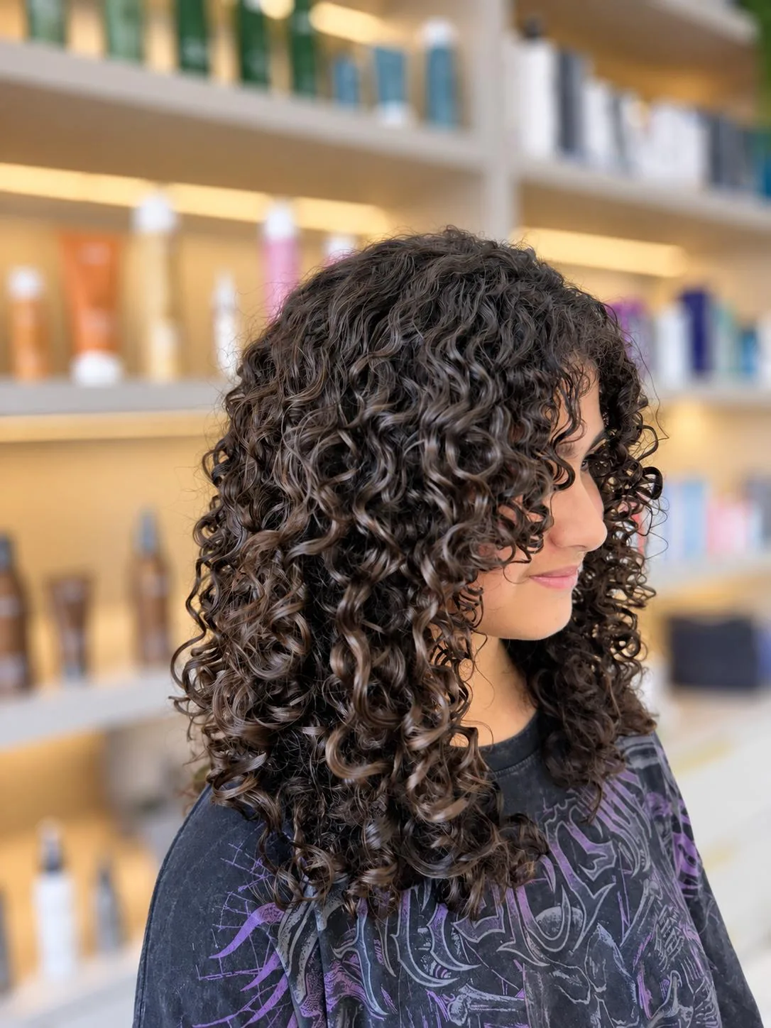 Dark shoulder-length hair with defined curls