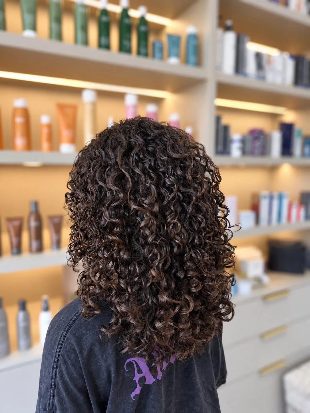 Glossy dark curly hair photographed from behind