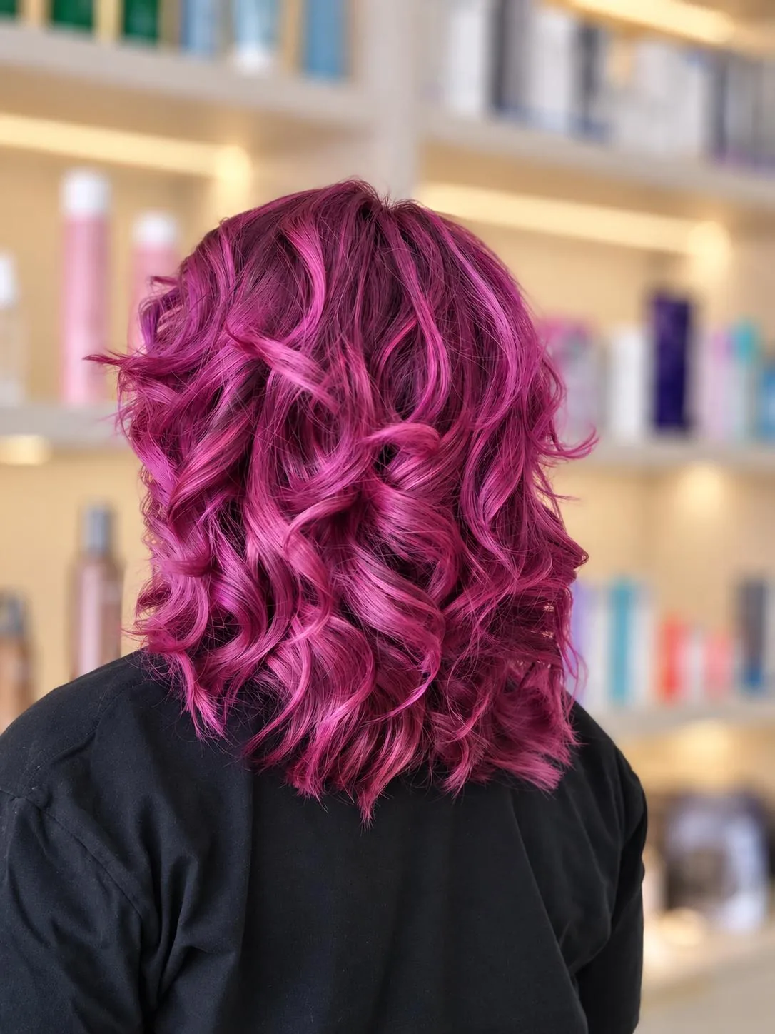 Vivid magenta hair styled in a wavy bob