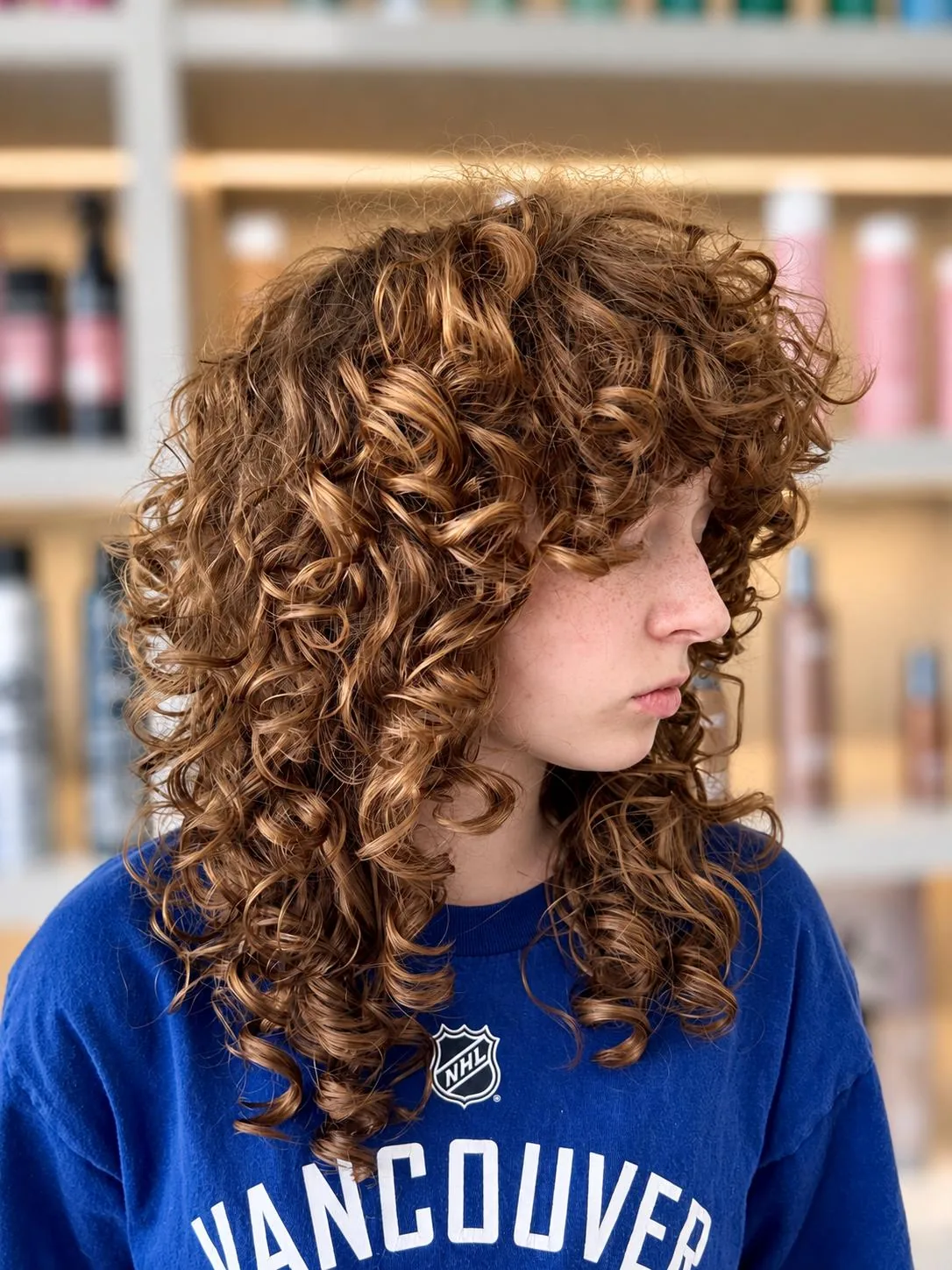 Long auburn curls with warm highlights
