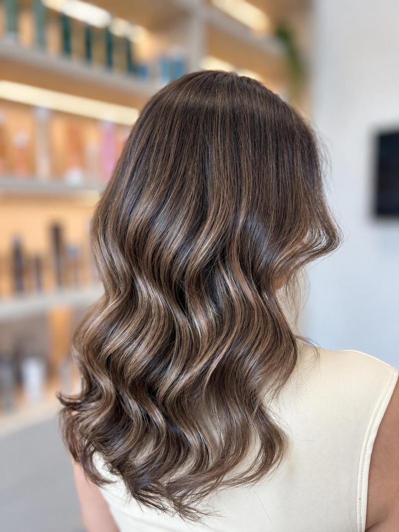 Long ash blonde hair styled in soft waves